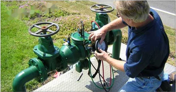 Technician testing a backflow prevention assembly outside an Annapolis property