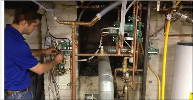 Technician wiring the controls on a newly installed hydronic boiler system