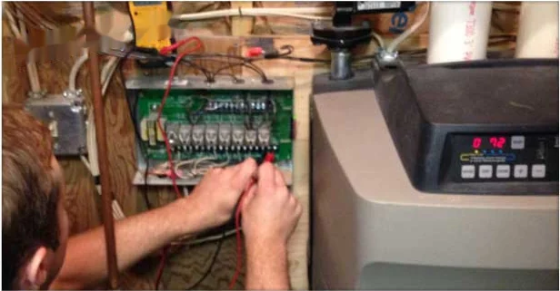 Technician testing control board wiring on a residential boiler