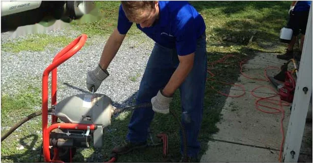 Technician running a drain cleaning machine at an Annapolis property