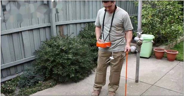 Technician using electronic leak detection equipment in an Annapolis yard