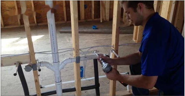 Plumber installing rough-in supply lines in a new construction home