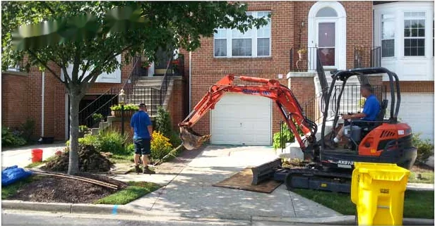 Mini excavator digging to reach a damaged sewer line at an Annapolis townhome