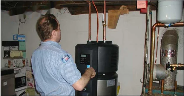 Heidler technician servicing a residential water heater in an Annapolis basement